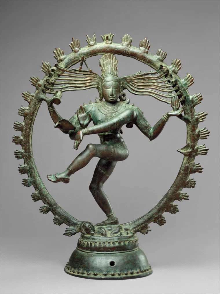 Bronze sculpture of four-armed Shiva dancing inside a ring of flames, with one leg raised and long locks of hair spreading outward