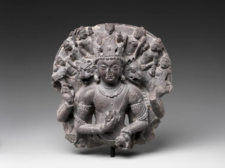Stone relief of Vishnu with multiple human and animal heads and smaller figures radiating around his upper body