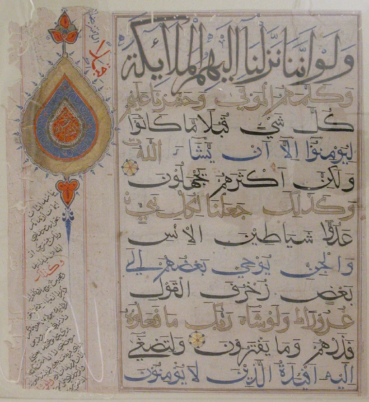 Late fourteenth-century Quran folio attributed to India, with large black Arabic script, colored diacritical marks, and an illuminated teardrop-shaped medallion