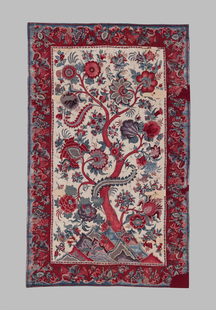 Painted cotton hanging with a branching red tree densely covered in red, blue, and purple flowers, surrounded by a floral border